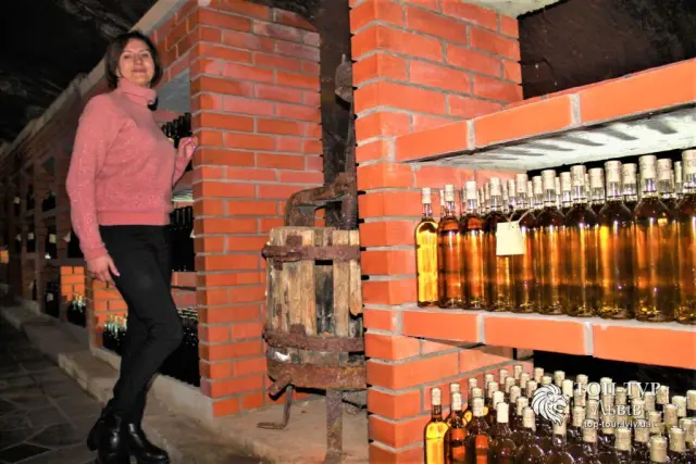 Туристка на фоне стеллажей с бутылками вина